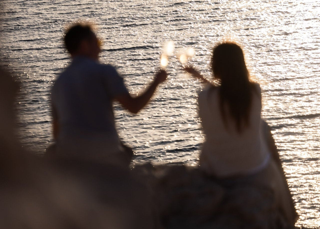 Couple clinking glasses of Beau Viva rosé outdoors