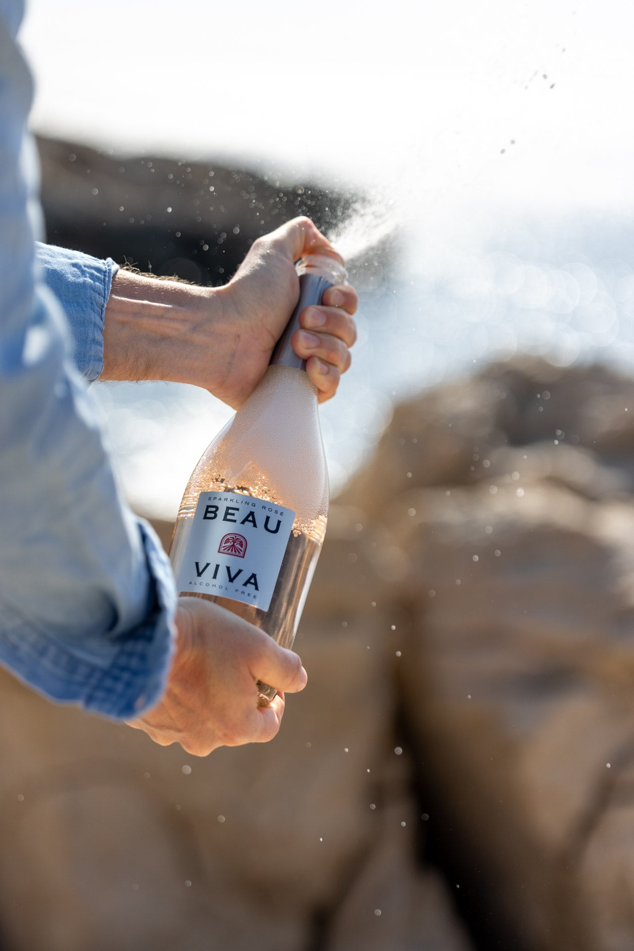 Opening Beau Viva sparkling rosé bottle outdoors