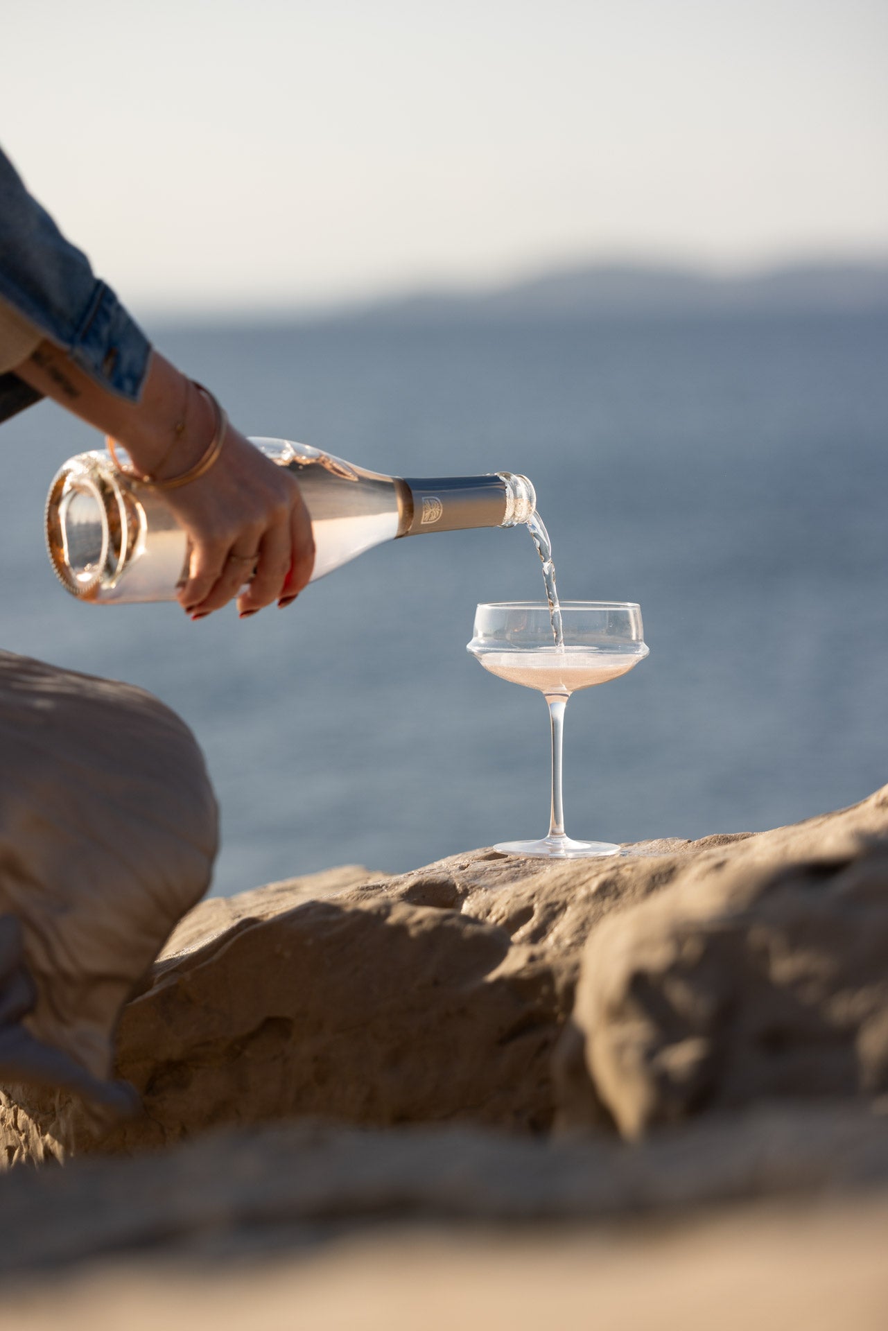  Pouring Beau Viva rosé wine into glass by the sea