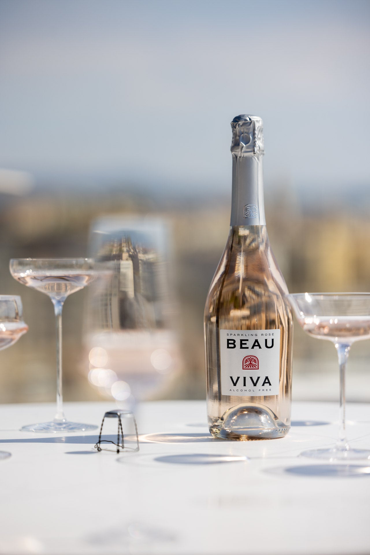 Beau Viva rosé bottle with glasses on rooftop table